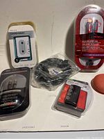 Photo showing Belkin cassette adapter, Rocketfish HDMI cable, remote control device, audio cables, and coiled cable arranged on table