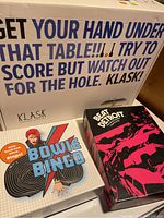 Three board games stacked and displayed: Klask, Bowie Bingo, and Beat Detroit.