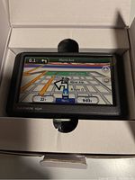 Garmin Nuvi 255w GPS device in box with screen on showing map navigation interface.