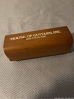 Wooden record cleaner block with branding House of Guitars, Inc., 645 Titus Ave.