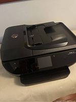 Front angle view of HP Envy 7644 all-in-one printer showing touchscreen and paper tray.