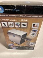 Box front showcasing the product image and features, highlighting the device's ability to convert negatives, slides, photos, and business cards to JPEG.
