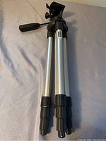 Full view of Manfrotto 390 tripod legs folded with black sections and silver aluminum leg tubes.