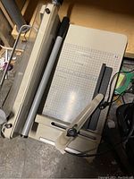 Top and side views showing the paper cutter base and blade handle with safety guard.