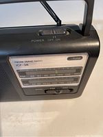 Close-up of front panel showing power switch, tuning scale, frequency markings for FM and AM, model label ICF-38.