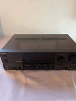 Front view of black Technics SA-GX330 AV control stereo receiver showing power button, input selector knobs, headphone jack, and Dolby Surround logo.