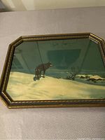 Full view of the framed vintage wolf print showing the wolf in snowy landscape and the ornamental gold-tone octagonal frame.