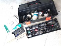 Overview of airbrush kit contents showing carrying cases, jars, cables, and paint bottles.