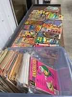 View of comics spread on a table showing a diverse collection with many vintage titles including the Inspector, Woody Woodpecker and others.