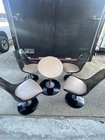 Five-piece set arranged outdoors showing four chairs around round table