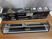 Tile cutter on top of its original box showing brand, size, and product images.