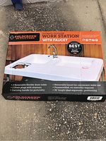 Top view of the unopened box showing the outdoor work station with faucet and product features