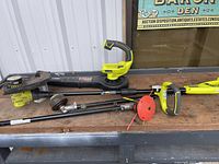Full view of Ryobi edger and blower with two attachments laid out on wooden surface