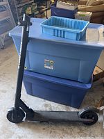 Full side view of black Swagtron electric scooter showing handlebar, deck, wheels, and folding mechanism.