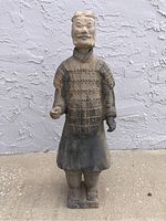 Front view of a terra-cotta statue of a Chinese man wearing traditional armor with detailed facial features.