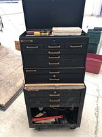 Front view of stacked three-piece black steel tool chest with drawers slightly worn