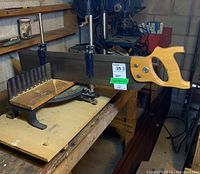 Angle saw platform on workbench with handle and saw frame visible
