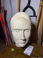 Front view of the clay bust showing facial features and hair texture