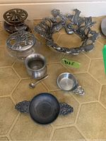 Set of Canadian pewter and glass pieces as described, showing decorative bowl holder, potpourri dishes, cranberry dish with spoon, and tea bag holders on hex tile surface.