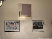 Photo showing three framed posters hung on a wall: top center abstract modern art from MoMA, bottom left Kandinsky abstract from Guggenheim, bottom right Cezanne & Pissarro nature scene.
