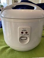 Front view of the white Zojirushi NRC-10 rice cooker with Cook and Keep Warm indicator lights and sliding switch.