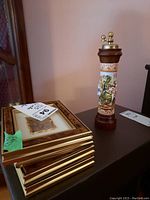 Four framed Lamina Argento 925 prints stacked on a table next to the ceramic side grinder.