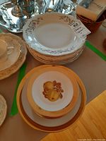 Stack of white china plates with floral designs and a tag labeled 82 'China B'
