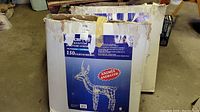 Two worn blue cardboard boxes for animated outdoor Christmas deer decorations, each with 150 lights and 48 inch height. Both boxes show image of wireframe deer and details about animation and collapsible wire construction.