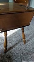 Side angle showing the wooden dough box table with visible wood grain and a turned leg.