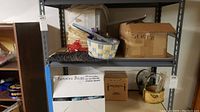 Shelf with boxes labeled for replacing bulbs and other items, various baskets on top shelf