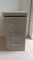 Front view of beige two-drawer metal file cabinet with handles and label holders