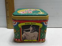 Square metal baseball collectible tin showing Babe Ruth image and name on one side, colorful vintage graphics, and ruler for size reference.