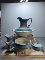 Full view of the 7 piece set showing large jug, basin, covered dish, and three smaller pitchers with blue and white gradient glaze and ornate detailing.