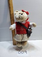 Front view of the Starbucks Bearista plush bear showing the full outfit and size beside a ruler.