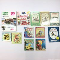 Photo of the full set of 11 children's books laid out flat showing titles and cover designs.