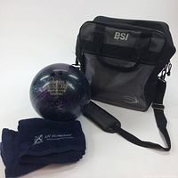 Photo of the bowling ball, two navy blue towels, and the black BSI ball bag with shoulder strap