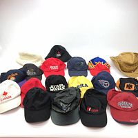 Overview photo showing all 18 caps and hats in a group, various colors and logos visible.