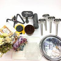 Overview of all items including solar lights, Tupperware container, sprinkler parts, screen, trays, artificial flowers, and more.