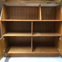 Front view of the partial hutch showing three top open compartments and lower cabinet with double doors open to four divided shelves.