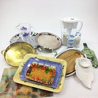 Wide shot of all lot items showing pitchers, filters, and various trays on a white background.