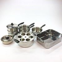 Full view of all set items showing pots, pans, roasting pan, and egg poacher
