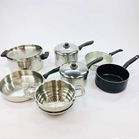 Full set of variety pots, pans and a steamer insert with lids and handles, on a white background.