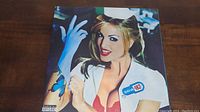 Front cover of Blink-182 Enema of the State vinyl album showing nurse with blue gloves and red bra.