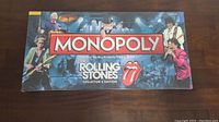 Front of box showing The Rolling Stones Monopoly Collector's Edition design with band members and iconic tongue logo.
