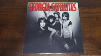 Front cover of Georgia Satellites vinyl album showing band photo with red title text.