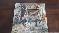 Front cover of The Best Of The Guess Who 2 featuring band members under a wooden bridge outdoors.