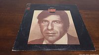 Front cover of the vinyl album showing a sepia portrait of Leonard Cohen with title text.