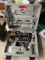 RotoZip Spiral Saw SCS III power tool in gray plastic carrying case with molded compartments for tool and accessories.