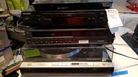Stacked electronics: top unknown device, Panasonic DVD player, Toshiba VHS VCR, Sony PS-X75 turntable