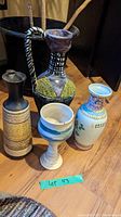 Five assorted ceramic vases and pots displayed on a wooden floor with a green lot label 43 visible.